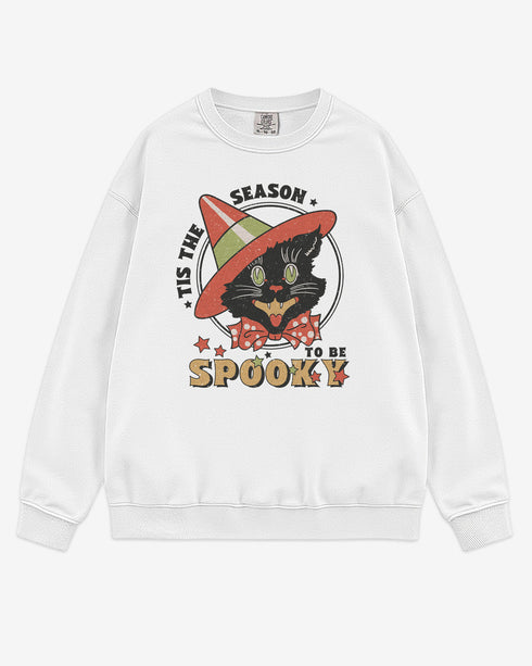 Flat lay white 'Tis The Season To Be Spooky' sweatshirt with retro Halloween graphic of a grinning black cat with hat.