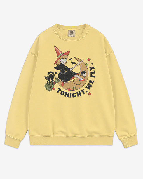 Flat lay butter Tonight We Fly sweatshirt with retro witch on broomstick, moon, and black cat Halloween graphic clothing.