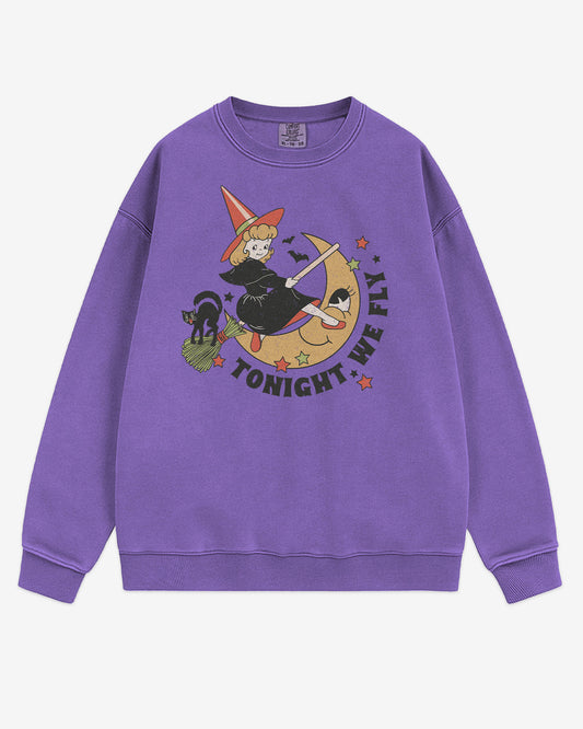 Flat lay violet Tonight We Fly sweatshirt with retro witch on broomstick, moon, and black cat Halloween graphic clothing.