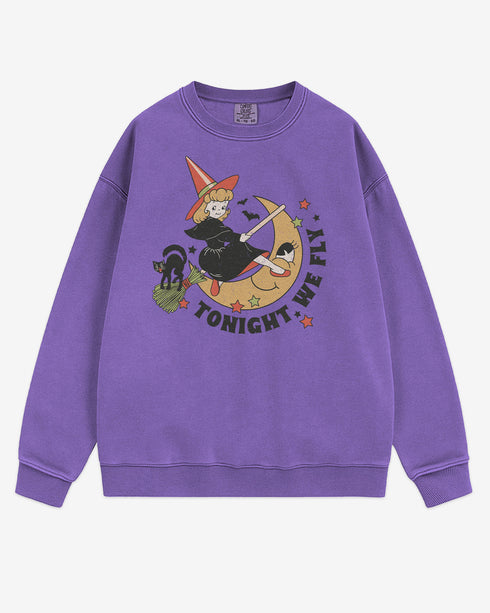 Flat lay violet Tonight We Fly sweatshirt with retro witch on broomstick, moon, and black cat Halloween graphic clothing.