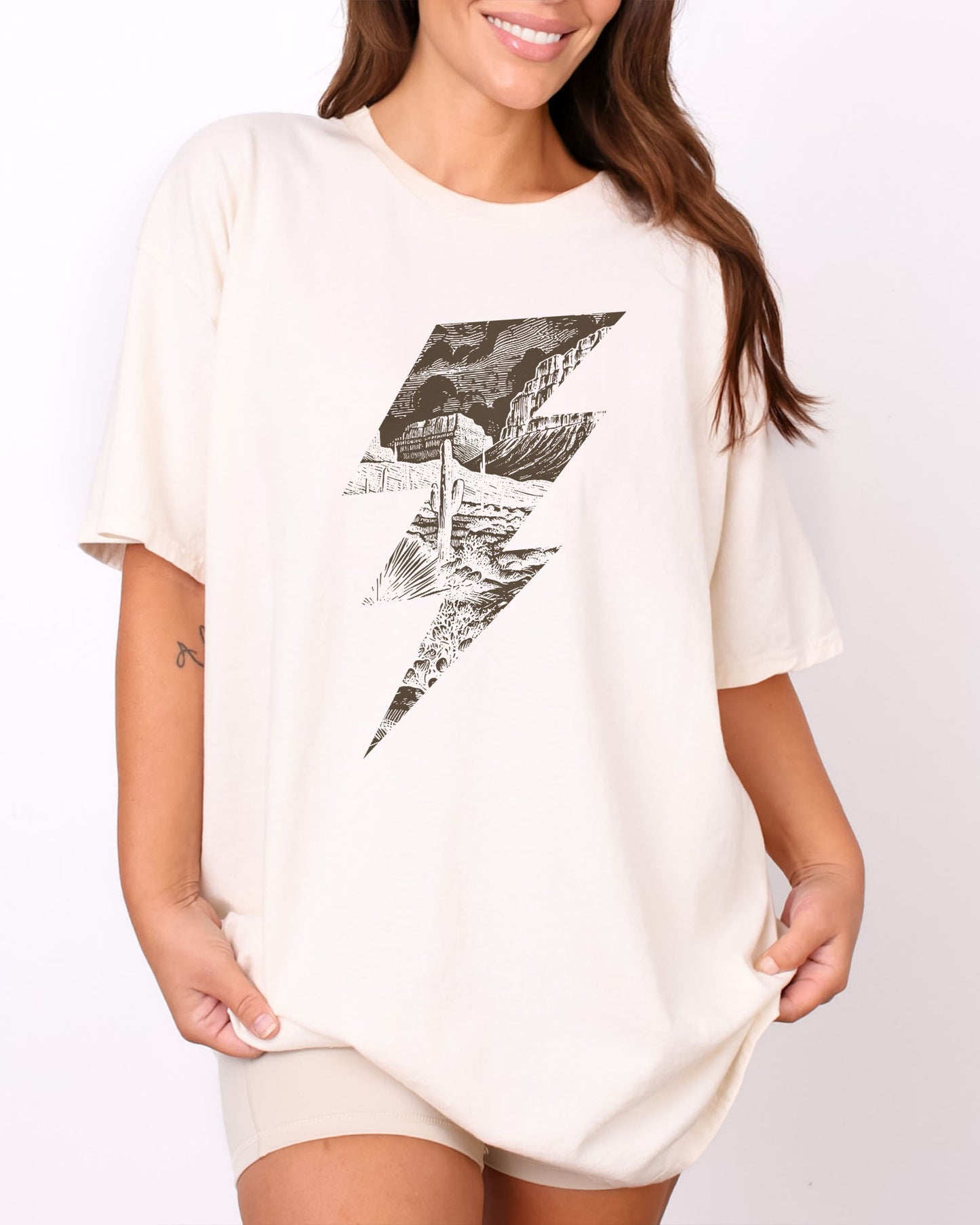 Model wearing natural color shirt with 'Western Lightning Bolt' graphic design