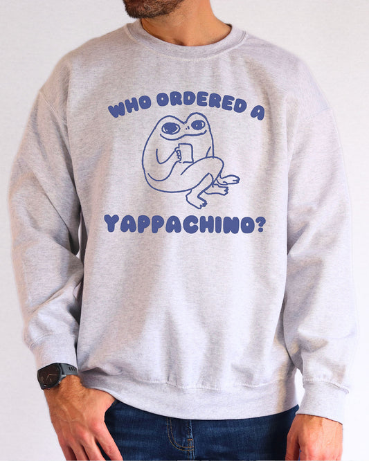 Model wearing ash color sweatshirt with 'Who Ordered A Yappachino' graphic design