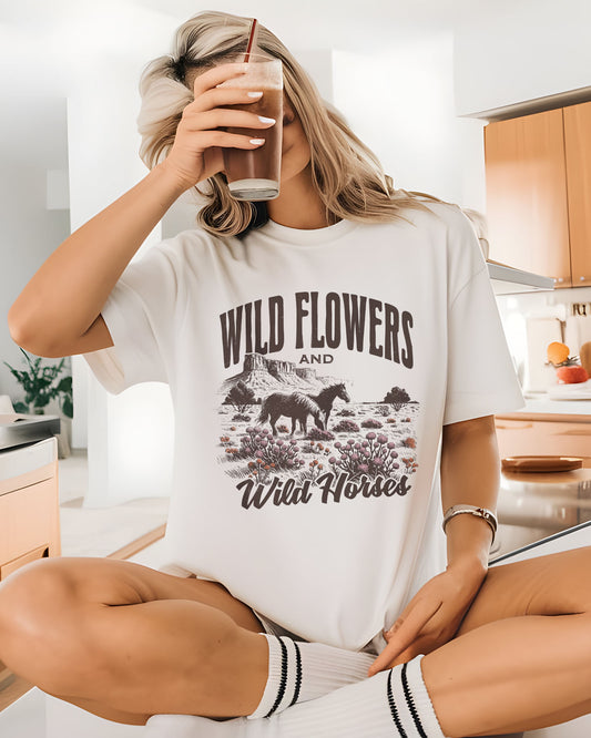 Model wearing white color shirt with 'Wild Flowers And Wild Horses' graphic design