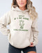 Woman wearing a sand beige hoodie featuring a funny retro country frog graphic and the quote 'Y'all Mind If I Do Some Lollygaggin''.