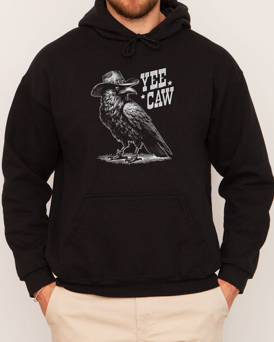 Man wearing a black-colored hoodie featuring a funny retro cowboy crow graphic and the quote 'Yee Caw'.