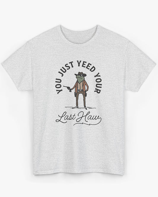 Flat laying ash gray 'You Just Yeed Your Last Haw' shirt with funny retro cowboy frog graphic