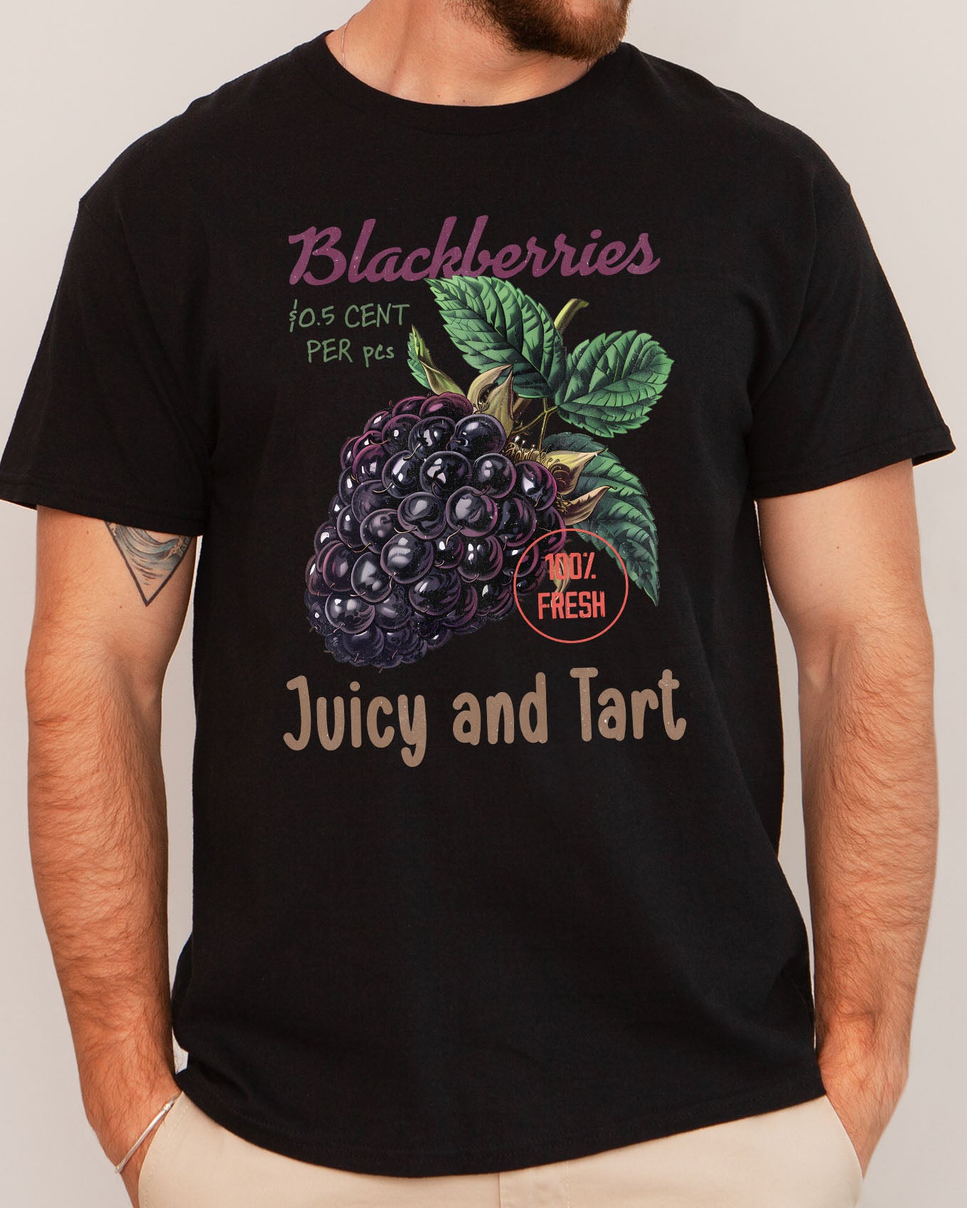 Man wearing a 'Blackberries - Juicy And Tart' shirt in black, featuring a retro blackberry commercial graphic design and unisex fit.