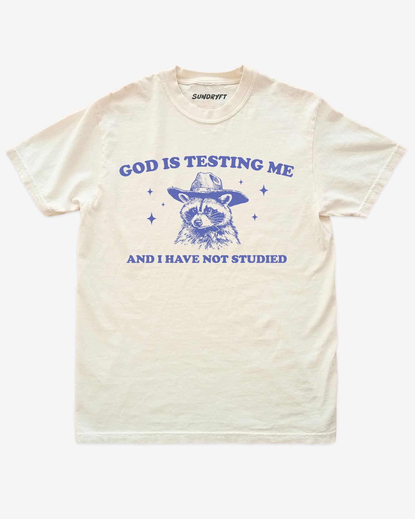 God Is Testing Me And I Have Not Studied shirt in ivory with cowboy raccon graphic