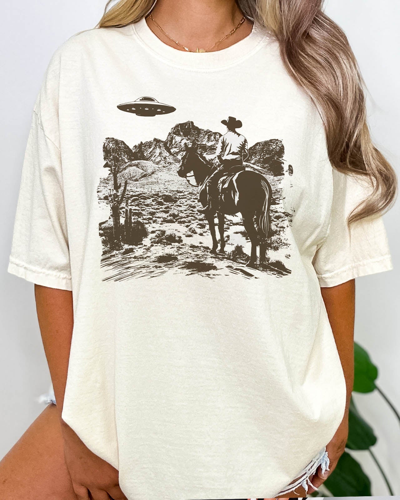 Woman wearing a retro UFO Western graphic shirt in natural color
