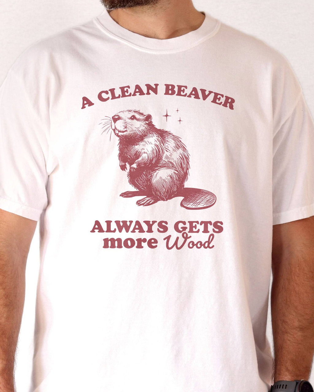 Close-up of man wearing white "A Clean Beaver Always Gets More Wood" shirt with funny retro beaver graphic.