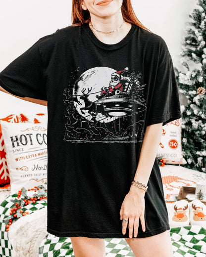Woman wearing an alien Santa graphic tee in black color.