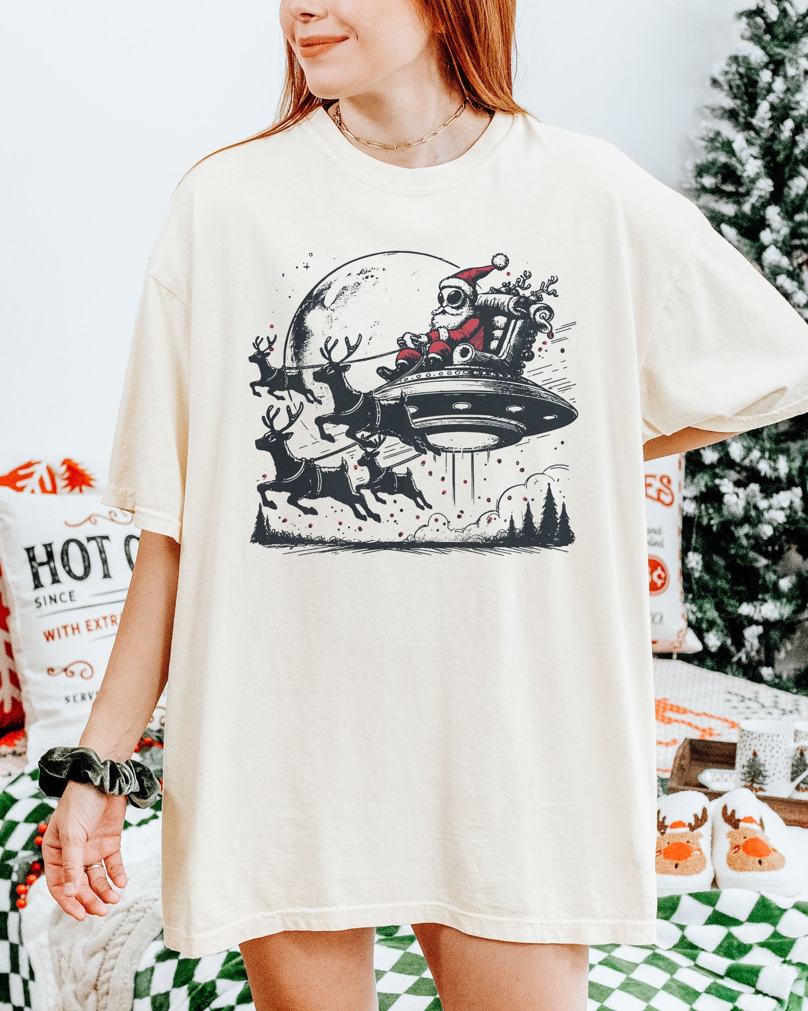 Woman wearing an alien Santa graphic tee in ivory color.