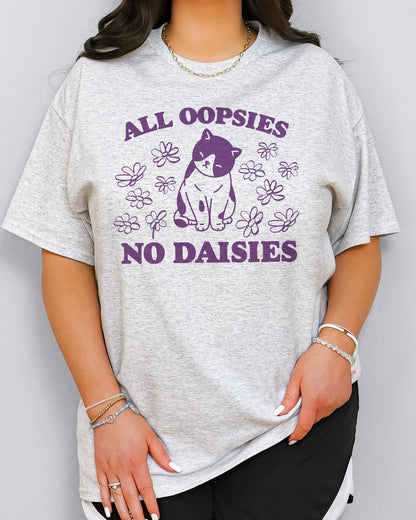 Model wearing ash color shirt with 'All Oopsies No Daisies' graphic design