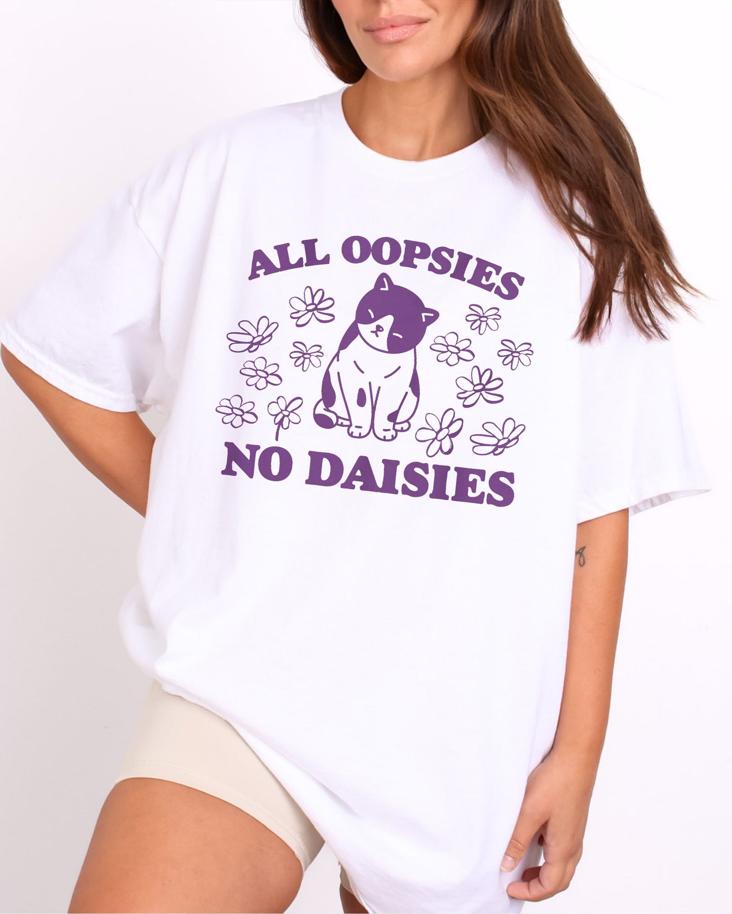 Model wearing white color shirt with 'All Oopsies No Daisies' graphic design