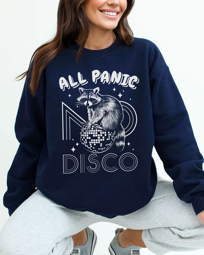 Woman wearing a navy blue sweatshirt featuring a funny retro raccoon sitting on a disco ball graphic and the quote 'All Panic No Disco'.