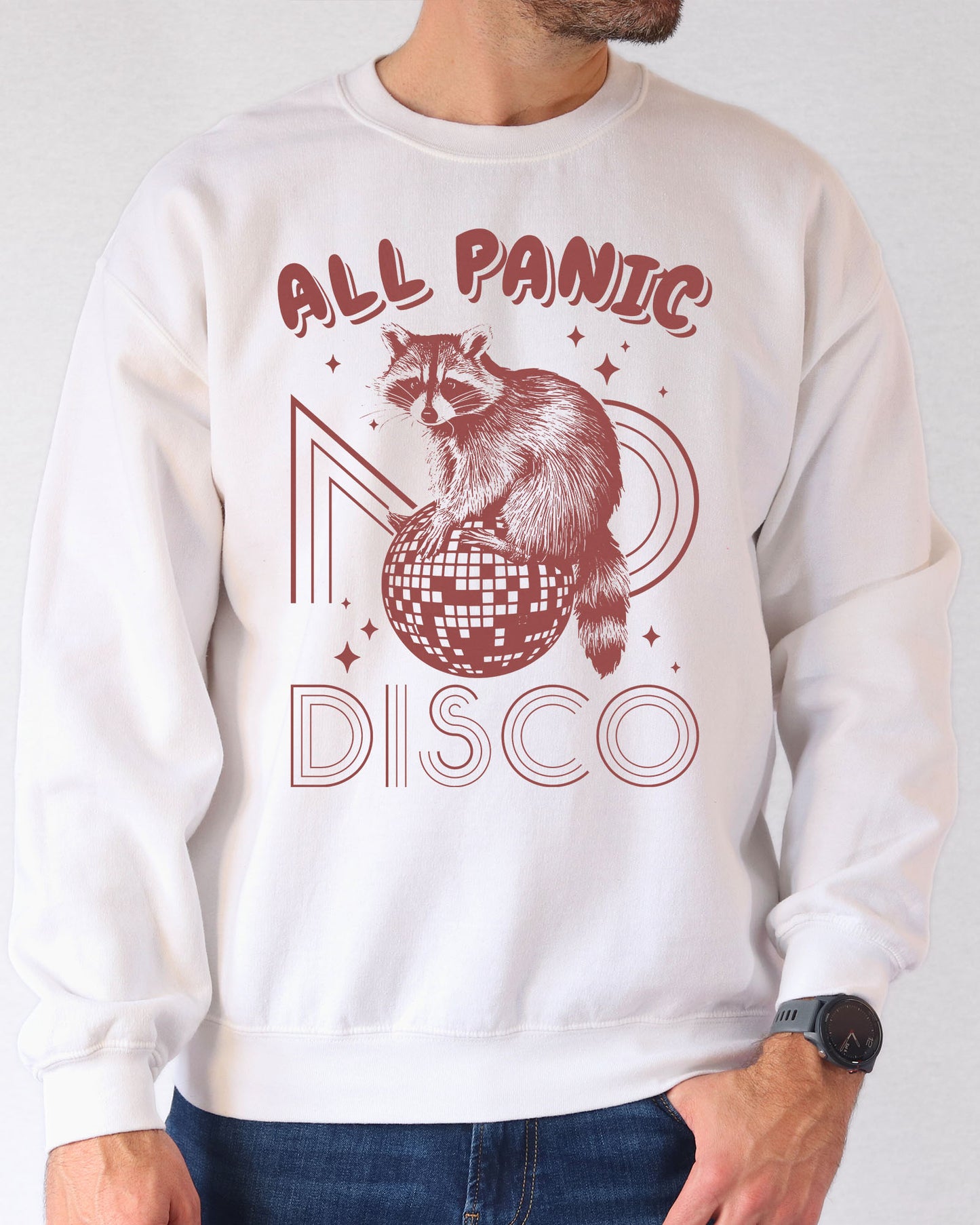 Man wearing a white sweatshirt featuring a funny retro raccoon sitting on a disco ball graphic and the quote 'All Panic No Disco'.