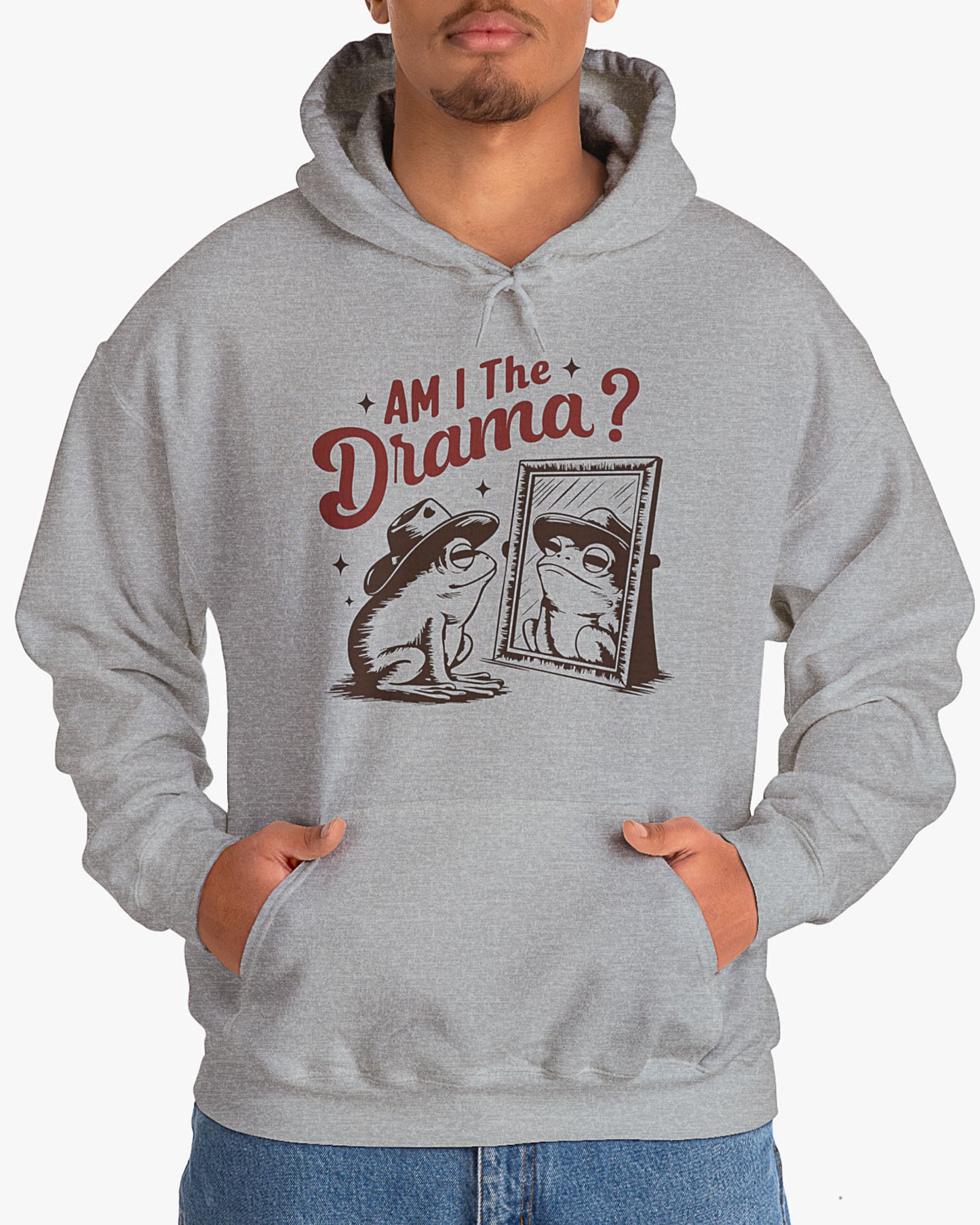 Man wearing sport gray 'Am I The Drama?' Hoodie with funny retro cowboy frog looking himself in the mirror graphic