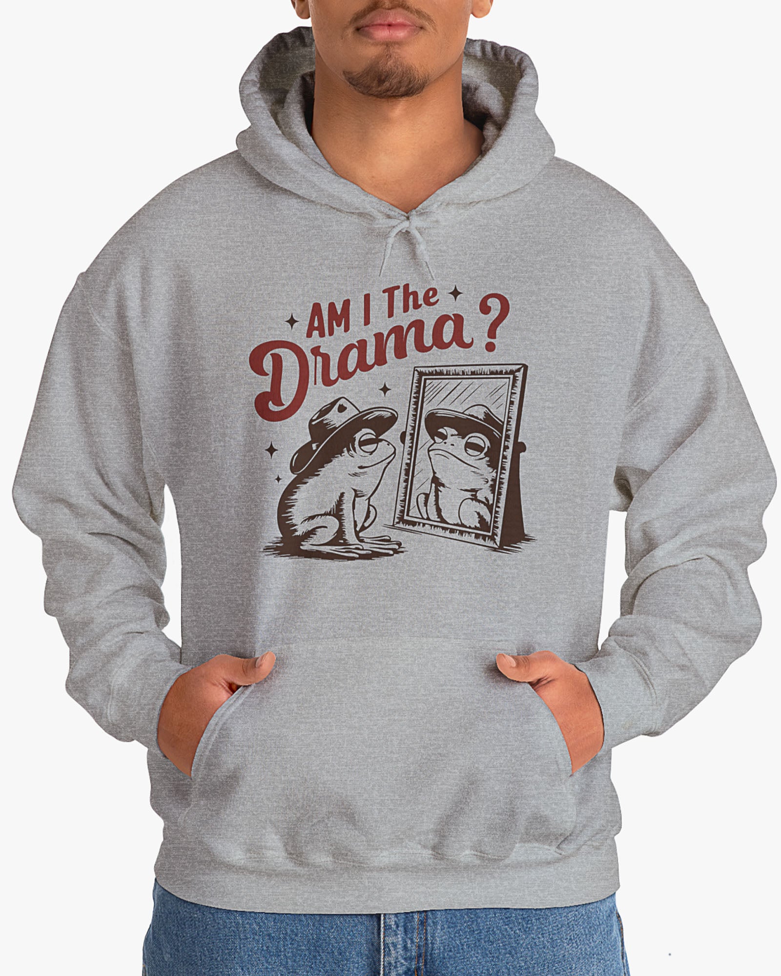 Man wearing sport gray 'Am I The Drama?' Hoodie with funny retro cowboy frog looking himself in the mirror graphic
