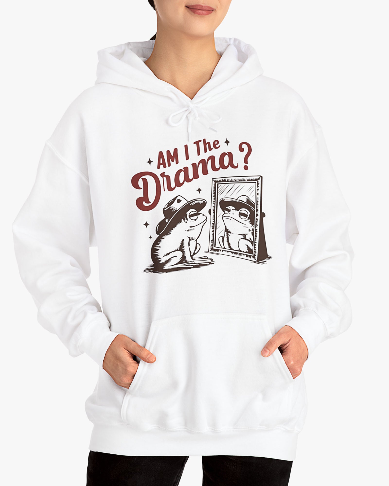 Woman wearing a white 'Am I The Drama?' hoodie featuring a funny retro cowboy frog looking at himself in the mirror graphic.