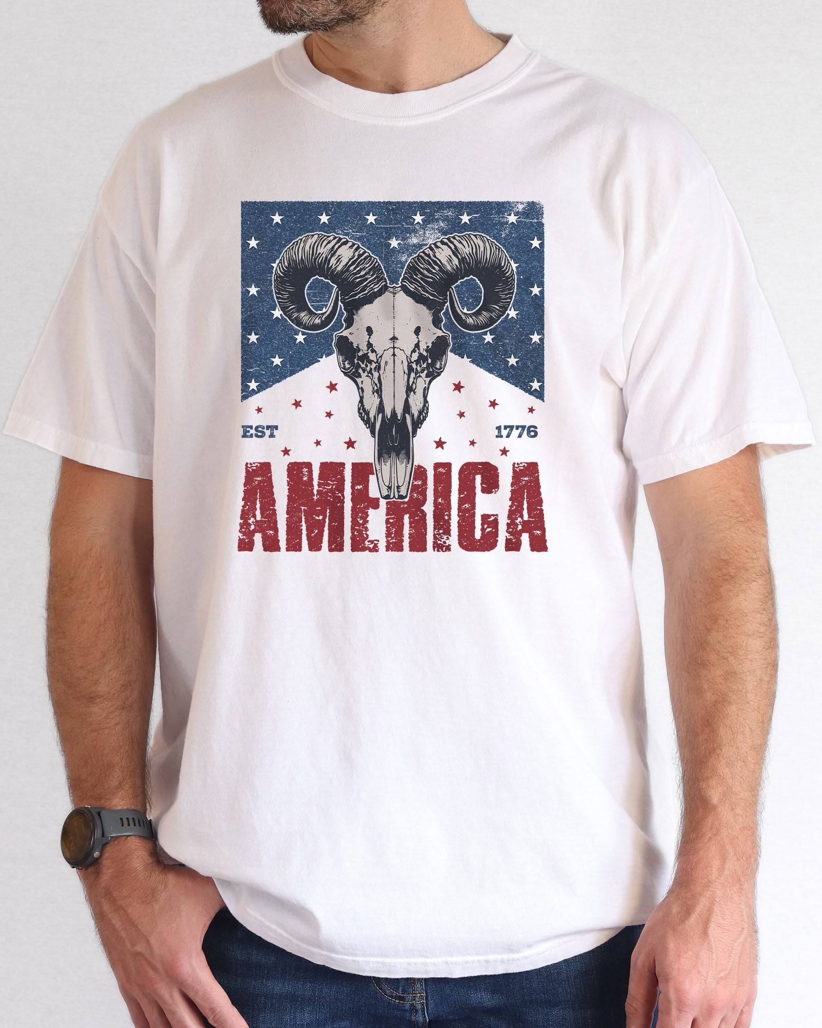 Model wearing white color shirt with 'America Est 1776' graphic design