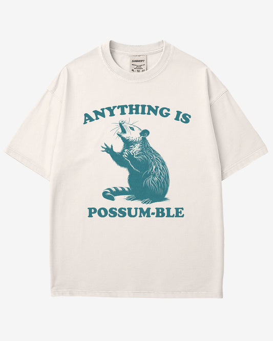 Flat lay white 'Anything Is Possum-ble' shirt with funny retro opossum graphic.
