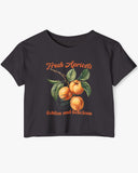 Flat-lay black crop top featuring a retro apricots fruit graphic in a vintage commercial style.
