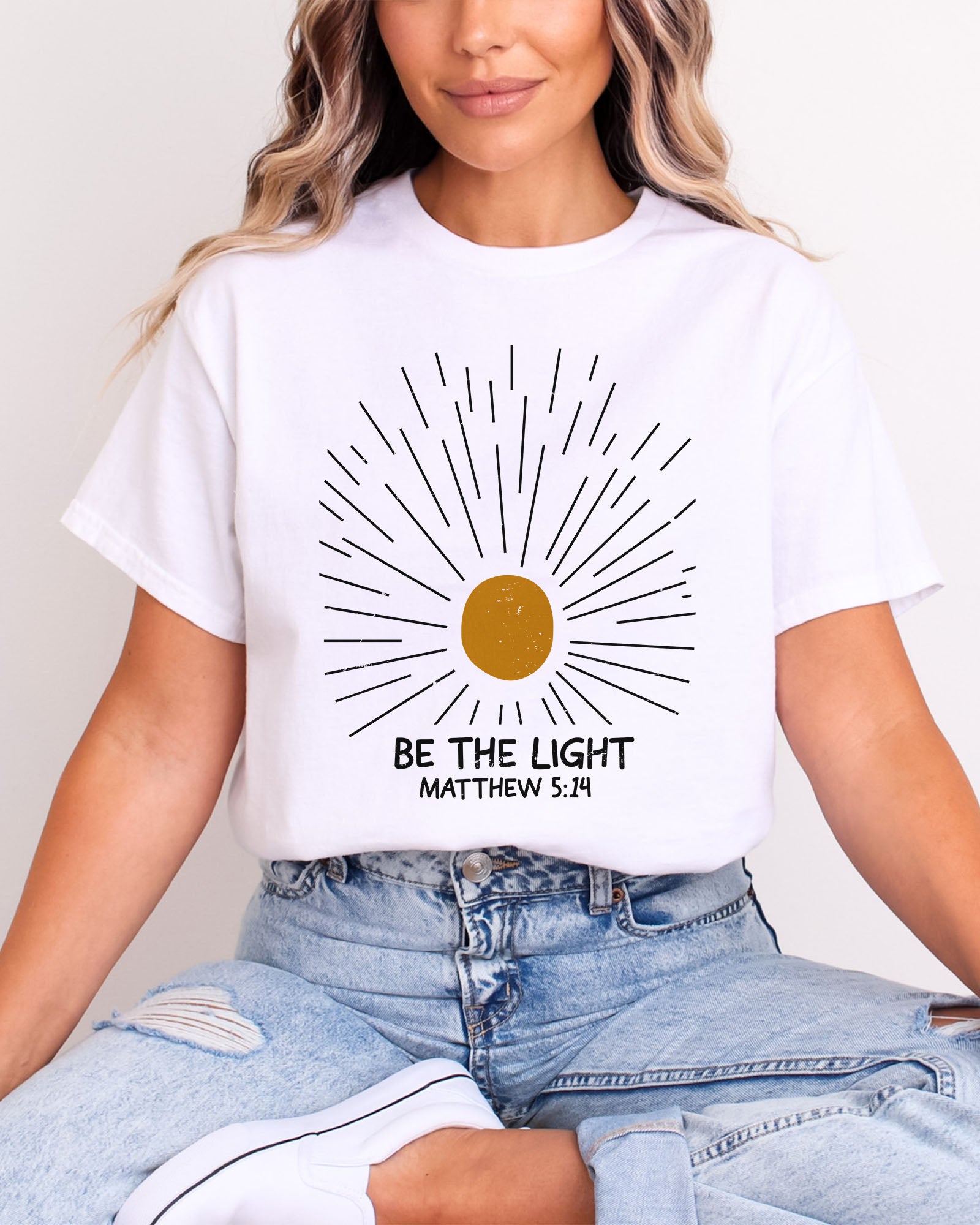Model wearing white color shirt with 'Be The Light - Matthew 5:14' graphic design