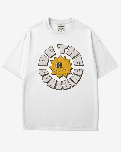 Flat lay white-colored Be The Sunshine shirt with a retro boho sun graphic.