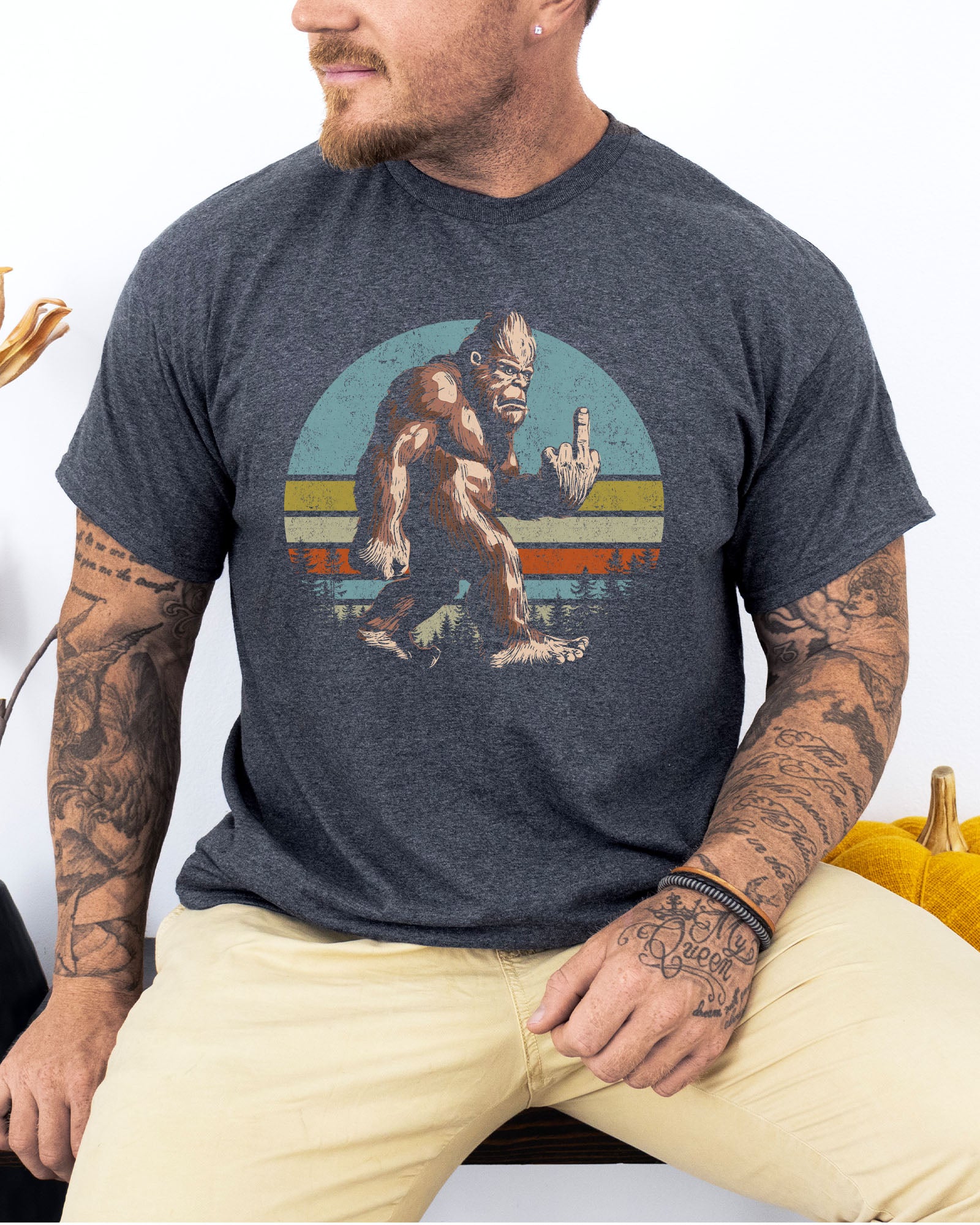 Model wearing dark heather color shirt with 'Bigfoot Showing Middle Finger' graphic design