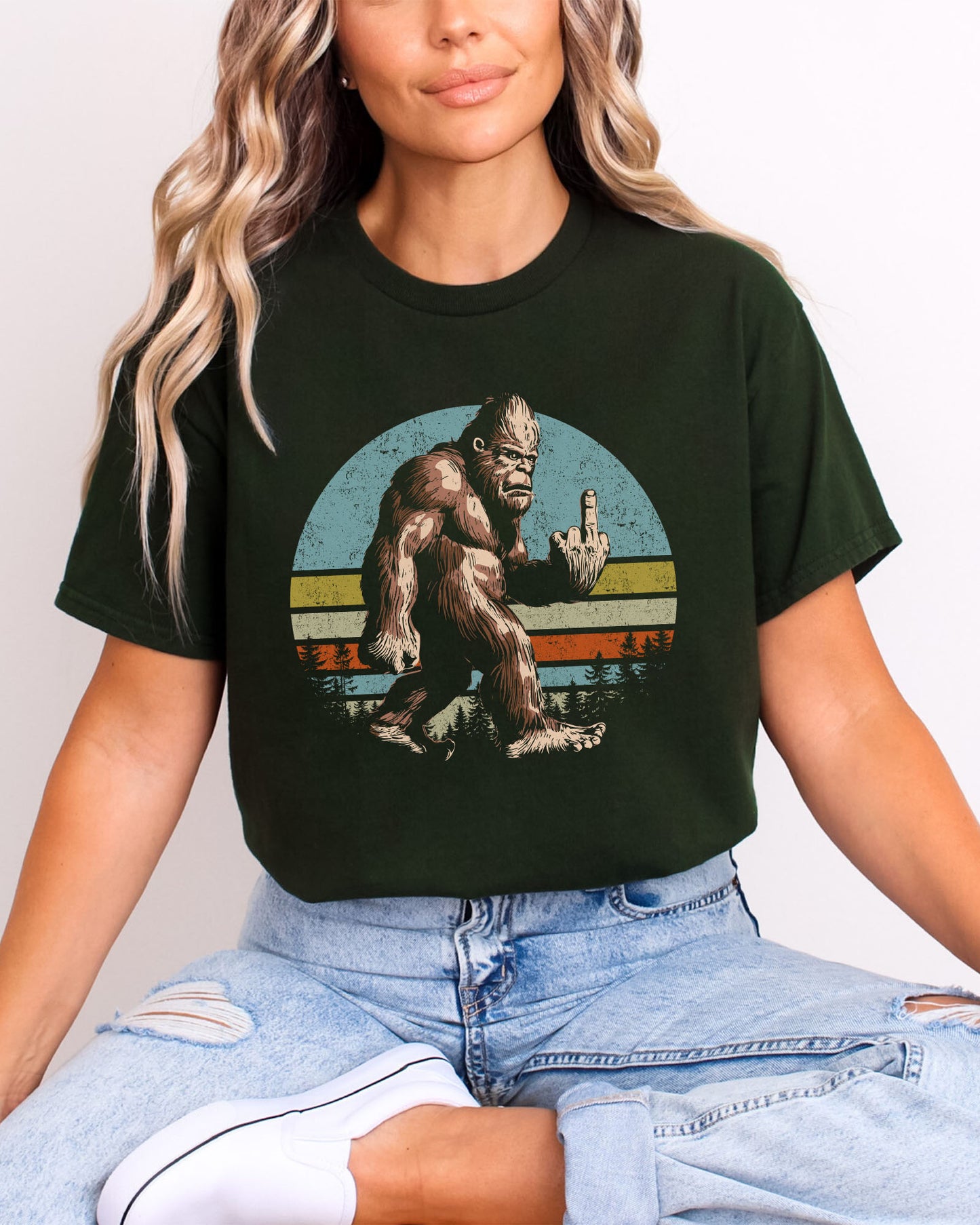 Model wearing forest green color shirt with 'Bigfoot Showing Middle Finger' graphic design