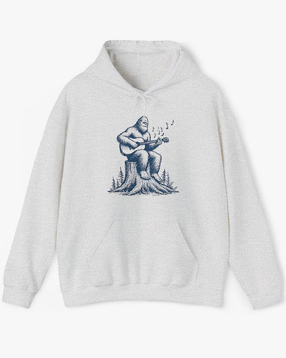 Flat lay ash gray hoodie with funny retro Bigfoot playing guitar graphic