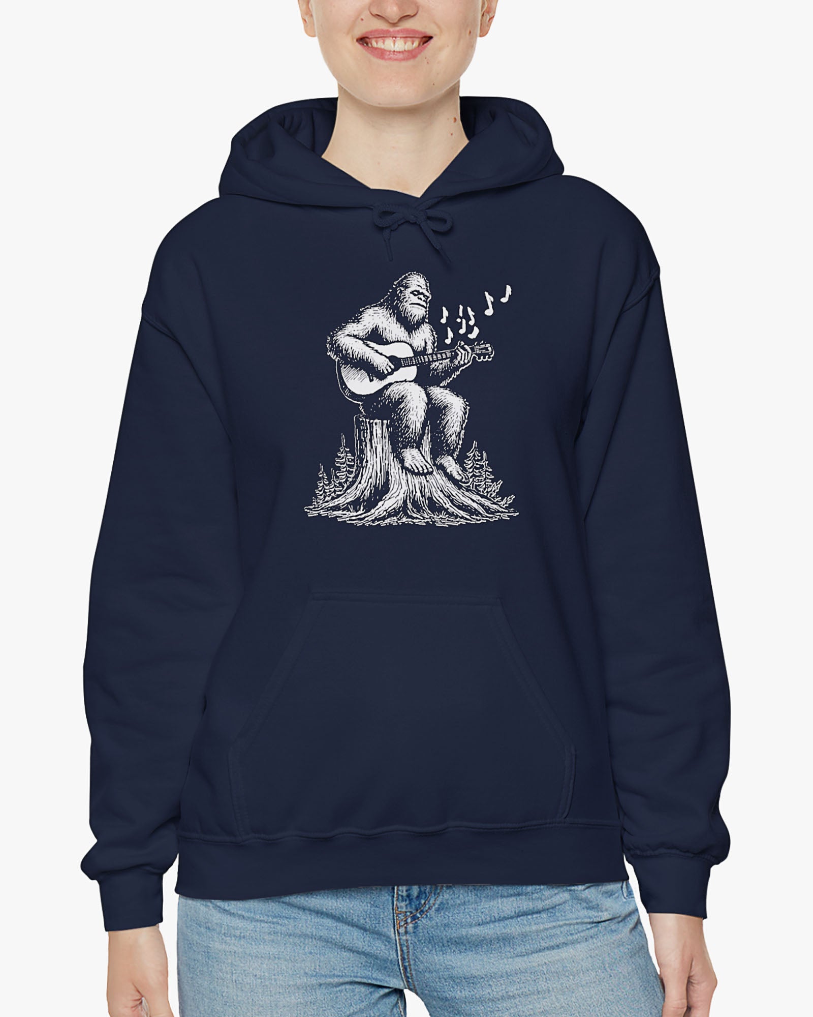 Woman wearing navy blue hoodie with funny retro Bigfoot playing guitar graphic