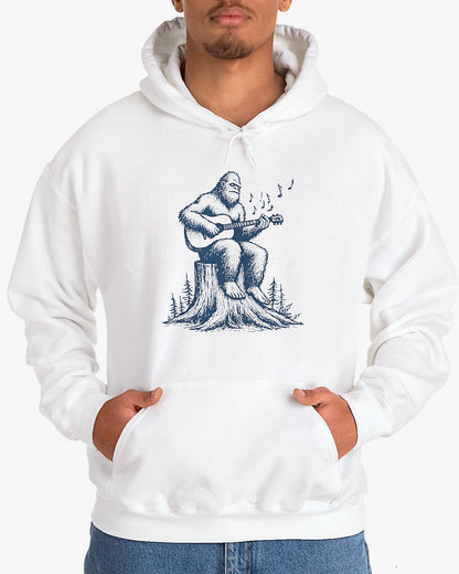 Man wearing white hoodie with funny retro Bigfoot playing guitar graphic