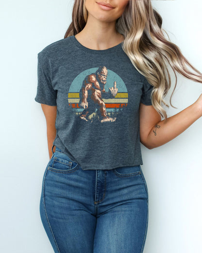 Woman wearing antique denim crop top with a funny retro-style Bigfoot flipping the middle finger graphic.