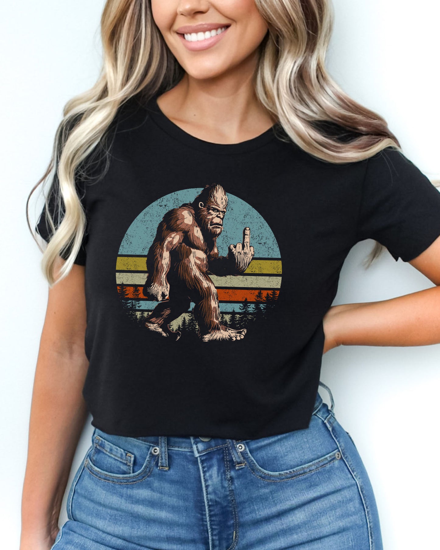 Woman wearing black crop top with a funny retro-style Bigfoot flipping the middle finger graphic.