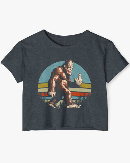 Flat lay of a antique denim crop top with a funny retro-style Bigfoot flipping the middle finger graphic.