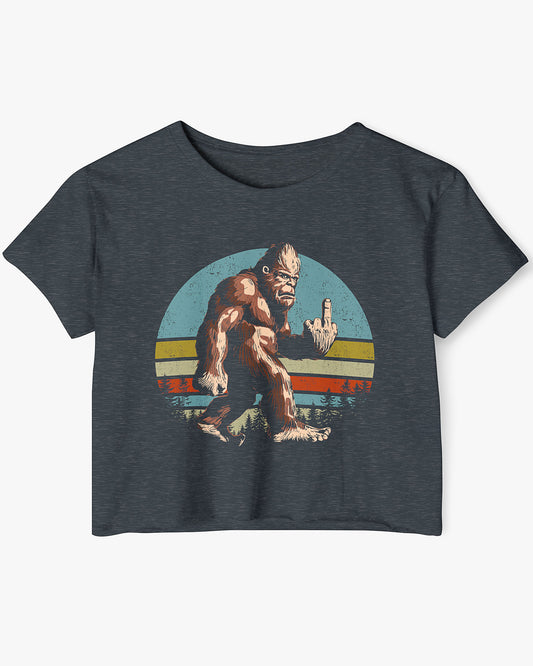 Flat lay of a antique denim crop top with a funny retro-style Bigfoot flipping the middle finger graphic.