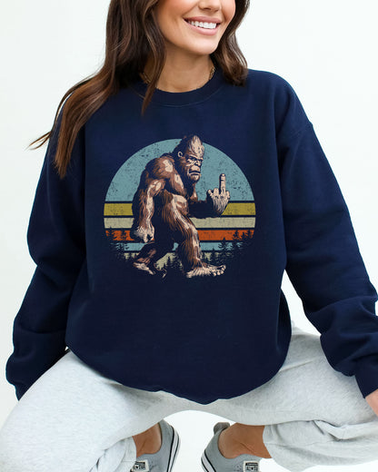 Woman wearing a navy blue sweatshirt featuring a funny retro-style Bigfoot showing the middle finger graphic.