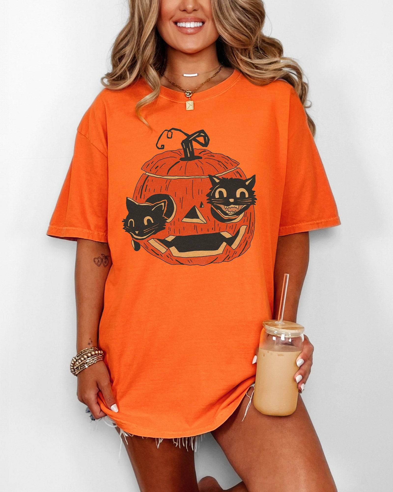 Woman wearing burnt orange--colored Black Cats in Pumpkin Shirt – retro graphic tee with two black cats inside a carved Halloween pumpkin
