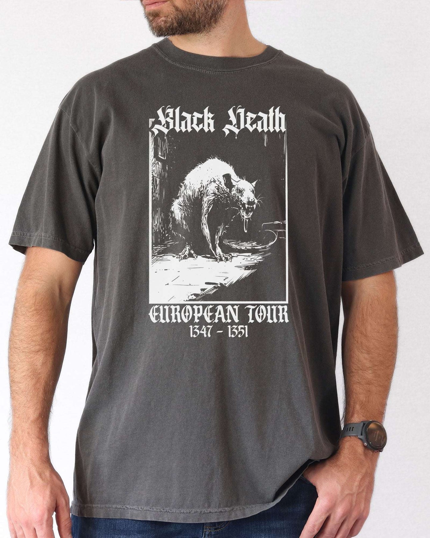 Man wearing a pepper-colored 'Black Death European Tour 1347–1351' shirt with a retro graphic of a medieval plague rat.