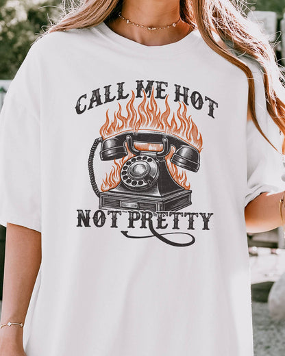 Close-up of woman wearing a white 'Call Me Hot Not Pretty' shirt with a retro graphic of a burning phone.
