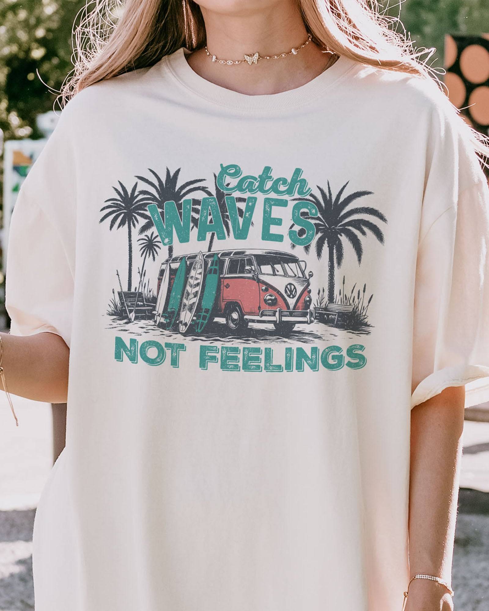 Close-up of model wearing ivory color shirt with 'Catch Waves Not Feelings' summer graphic design