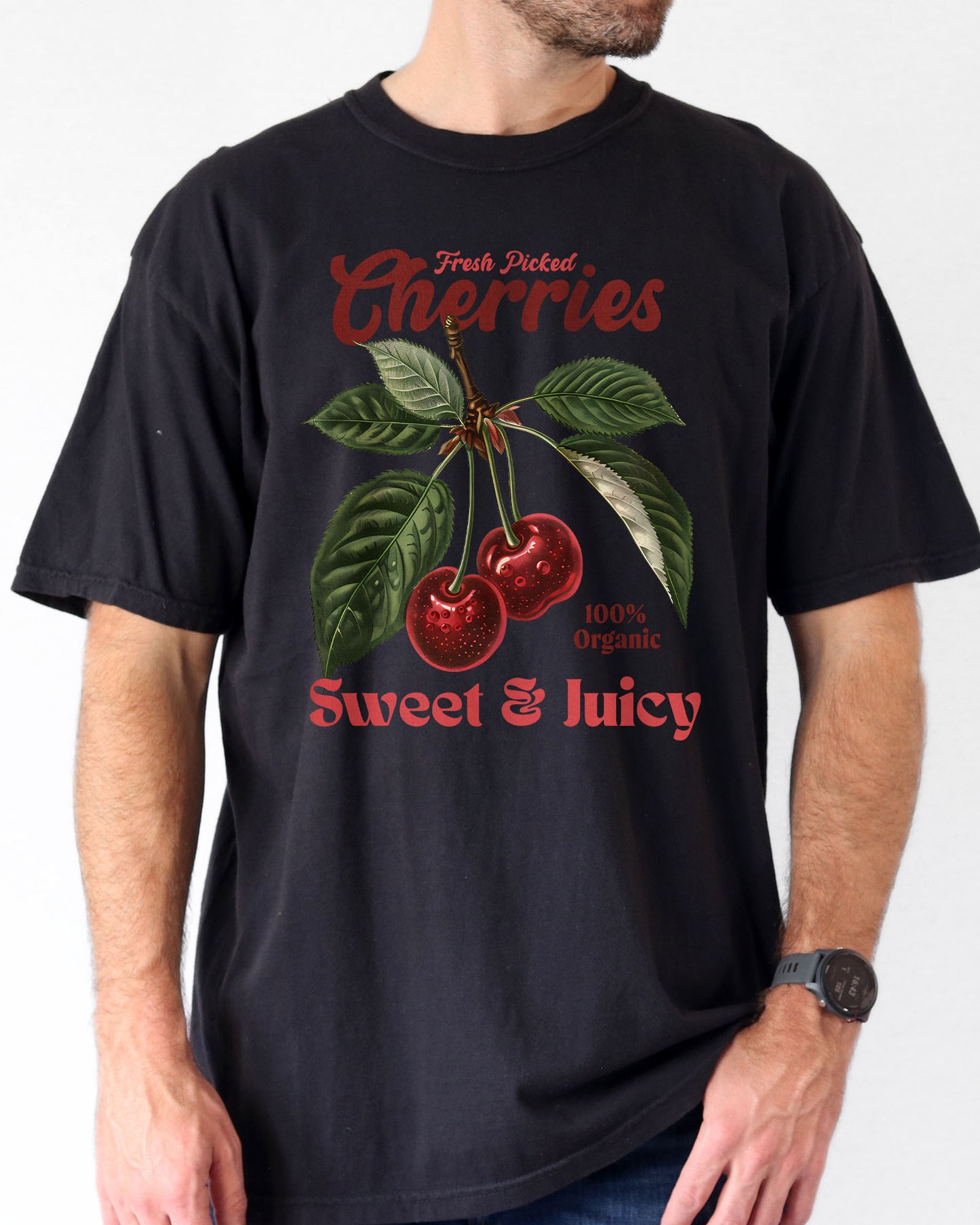 Man wearing a black "Cherries - Sweet & Juicy" shirt with a retro cherry graphic.