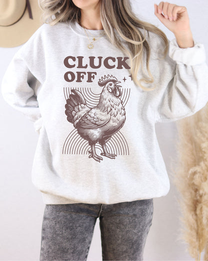 Model wearing ash color sweatshirt with 'Cluck Off' graphic design