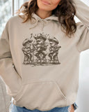 Woman wearing sand-colored hoodie featuring a funny retro country frog band graphic.