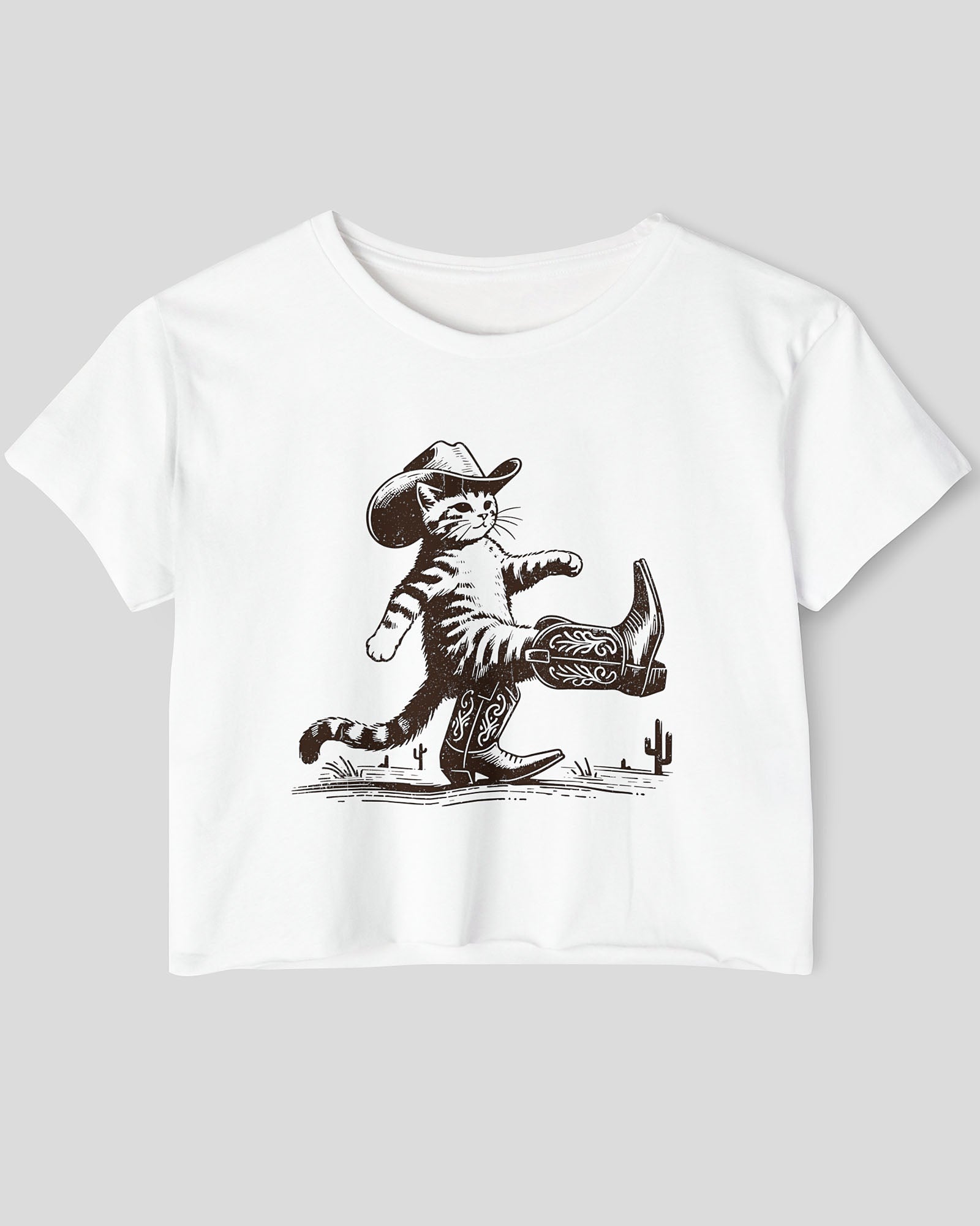 Flat lay white crop top featuring a funny retro cowboy cat graphic.