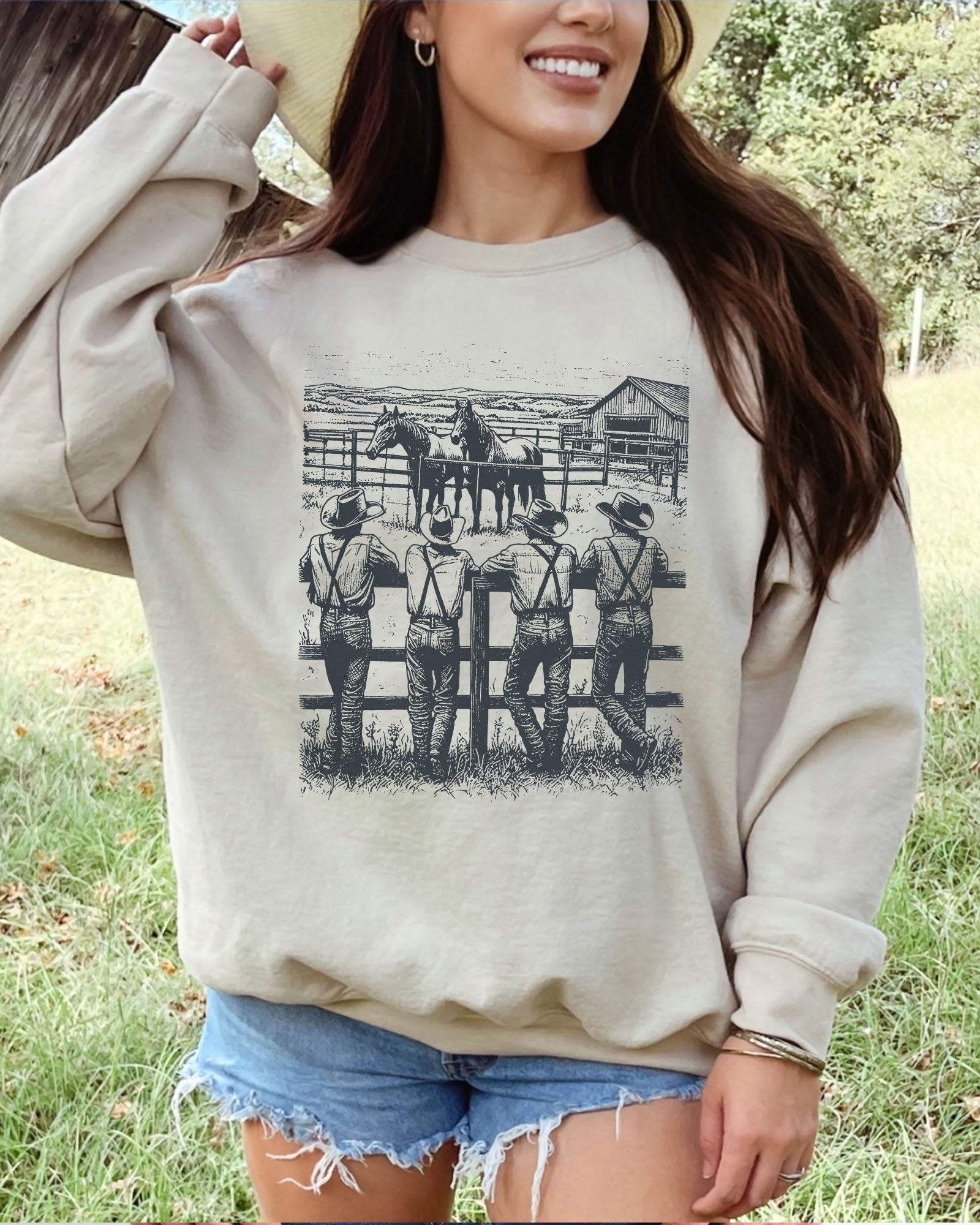 Model wearing sand color sweatshirt with 'Cowboy Gang' graphic design