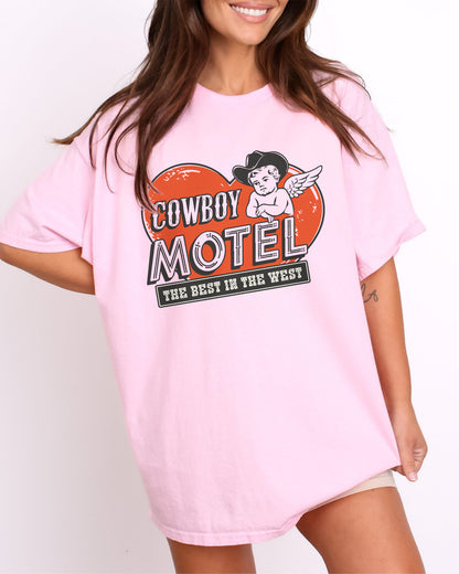 Model wearing light pink color shirt with 'Cowboy Motel - The Best In The West' Valentine's Day graphic design