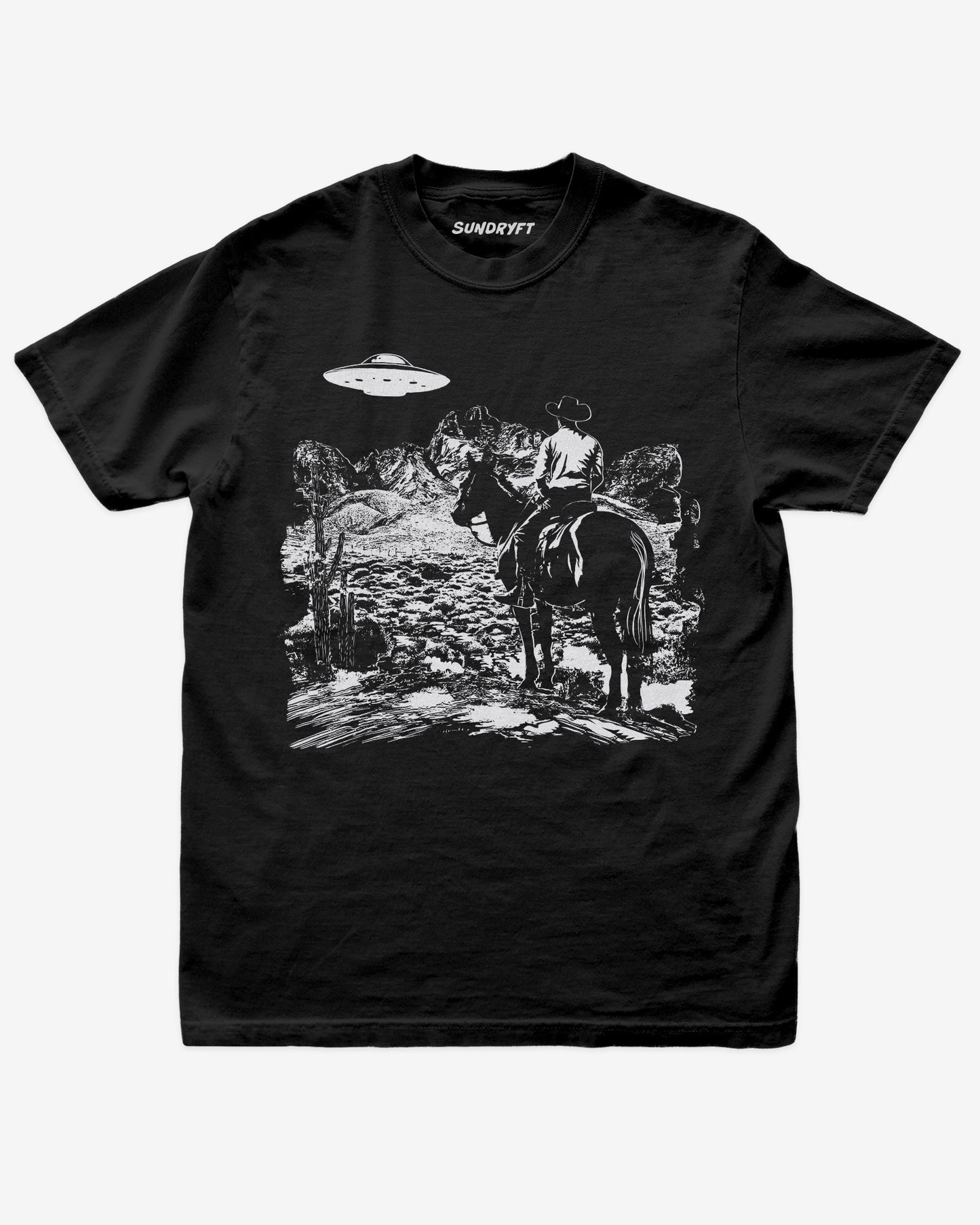 Black “Cowboy UFO” shirt with cowboy riding horse through desert under UFO graphic flat lay.