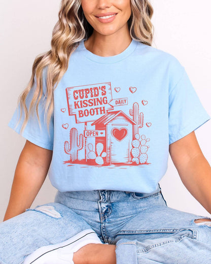 Model wearing light blue color shirt with 'Cupid's Kissing Booth' graphic design
